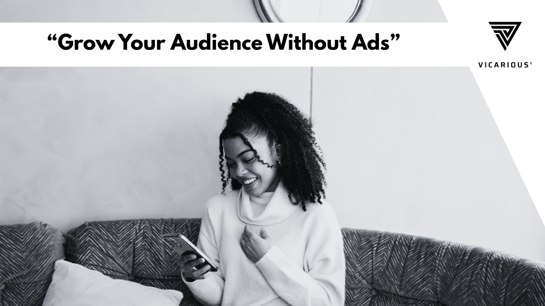 African digital content creator smiling while engaging followers on a mobile phone without paid promotion.